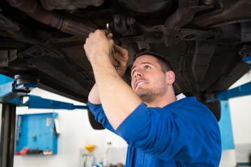 Wall Mural - Mechanic examining under the car