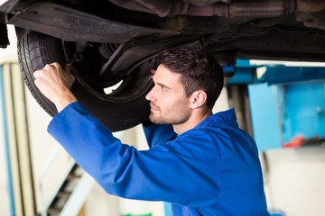 Poster - Mechanic adjusting the tire wheel