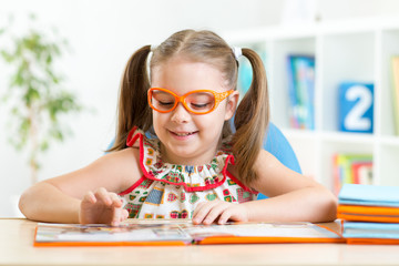 Wall Mural - Little girl reading a book