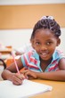© WavebreakMediaMicro - Cute pupils writing at desk in classroom