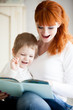 © fizkes - Mom reading her son book
