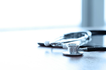 Stethoscope with digital tablet computer on wooden table and  ba