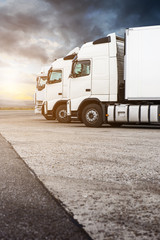 Three white trucks in a row