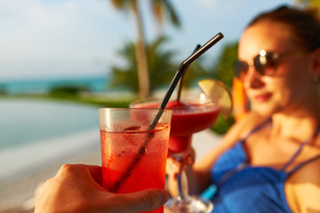 Canvas Print - Couple clinking glasses with cocktails