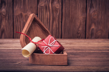 Wall Mural - Rolled paper and gift box on Valentine's day over defocused vint