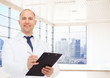 © Syda Productions - smiling male doctor with clipboard