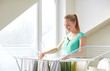© Syda Productions - happy woman hanging clothes on dryer at home