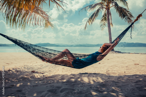 Valokuva Woman relaxing in hammock on tropical beach
