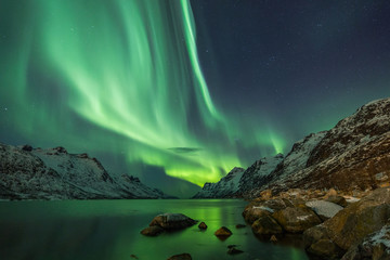 aurora borealis reflected between two fjords in tromsø