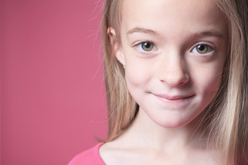young girl poses for a picture isolated on pink