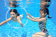 Kids swim in pool underwater, girls swimming and having fun