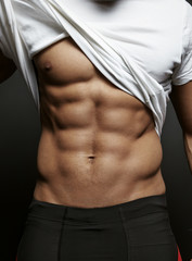 Closeup photo of an athletic guy with perfect abs