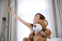 Smiling Woman Taking A Selfie Portrait With Teddy Bear
