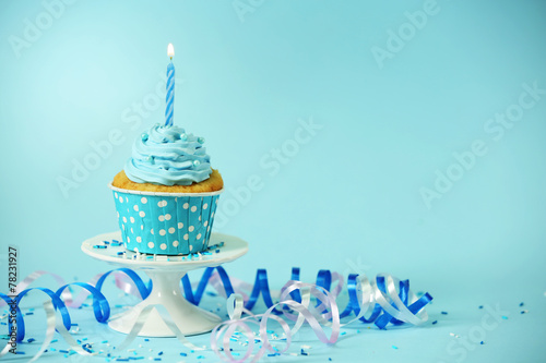 Obraz na plátne Delicious cupcake on table on blue background