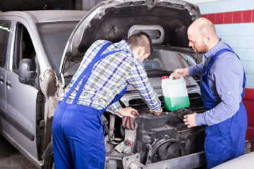 Two car mechanics at workshop