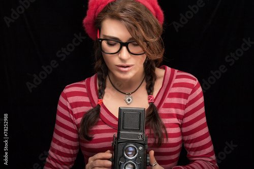 Fototapeta na wymiar Young Woman Capturing Photo Using Vintage Camera