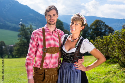 Fotografie, Obraz Paar in Tracht steht auf Alm in den Alpen