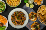 Fototapeta Tulipany - Sports feast - chicken wings, vegetable, french fries, pizza