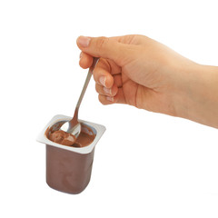 Wall Mural - Spoon with chocolate pudding, coffee, baby food in hand on a whi