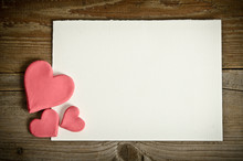 White Paper With Small Pink Hearts Lying On A Wooden Background