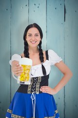 Wall Mural - Composite image of pretty oktoberfest girl holding beer tankard