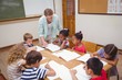 © WavebreakmediaMicro - Teacher and pupils working at desk together