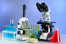 Microscopes And Test Tubes On Table, On Color Background