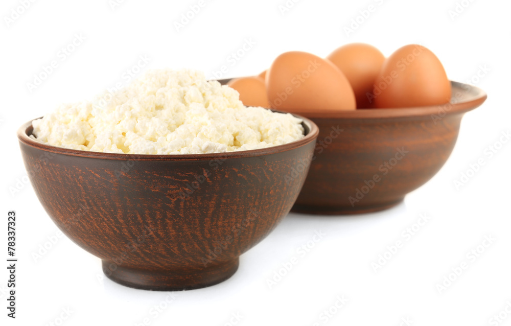 Cottage cheese and eggs in clay bowls isolated on white