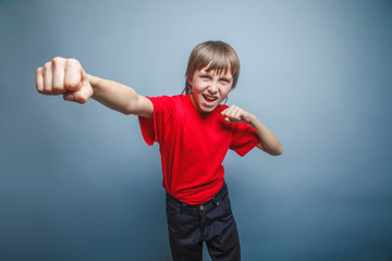 European-looking boy of ten years shows a fist, anger, danger, m