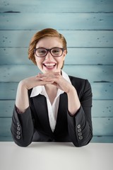 Poster - Composite image of redhead businesswoman sitting at desk