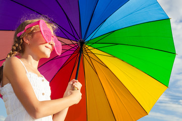 Poster - teen girl standing with umbrella on the blue sky background