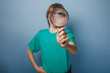 © maxximmm - European-looking boy of ten years is looking through a magnifyin