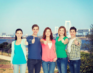 Wall Mural - group of smiling students showing thumbs up