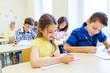© Syda Productions - group of school kids writing test in classroom