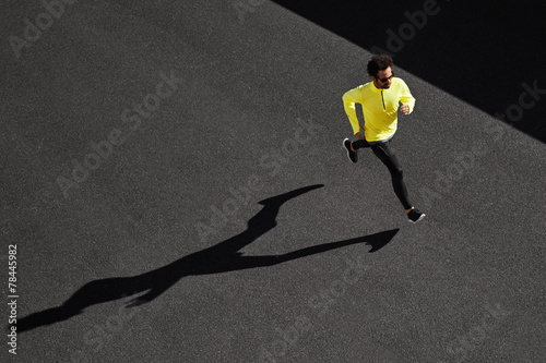 Fotografía Running man sprinting for success on run. Top view athlete runne