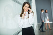 © BGStock72 - Young woman in office with mobile phone