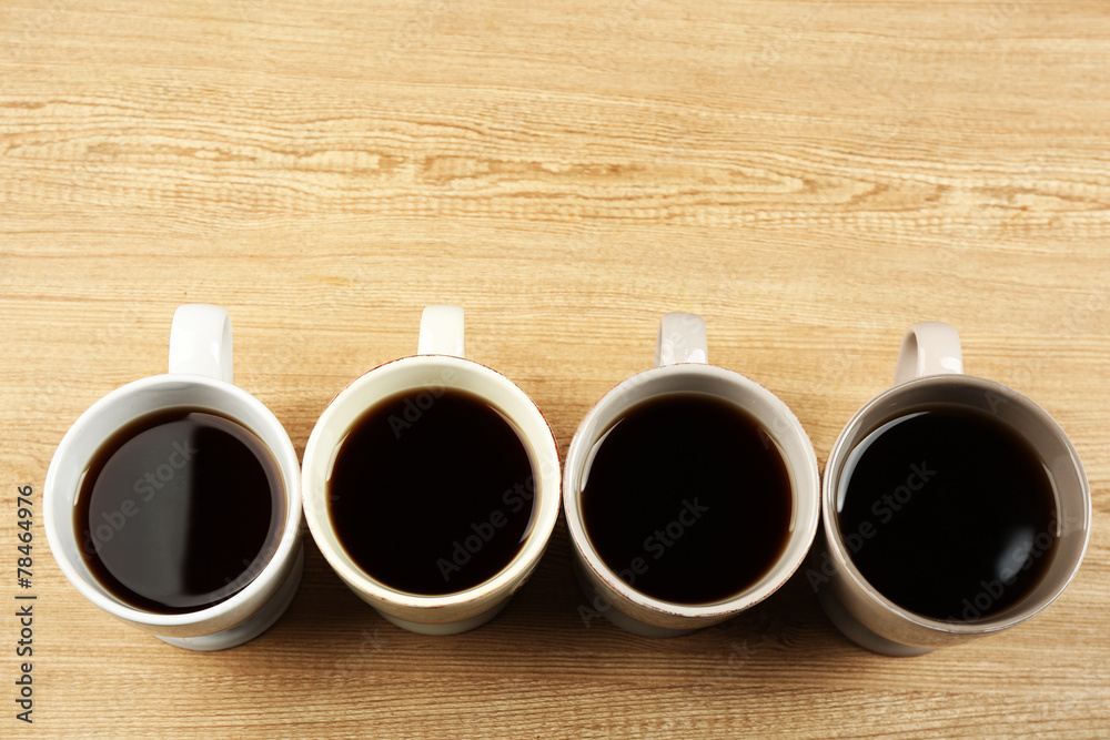 Cups of coffee on wooden table background