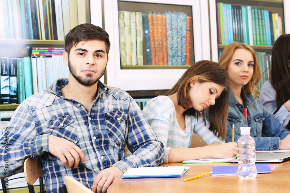 Group of students sitting at table in library