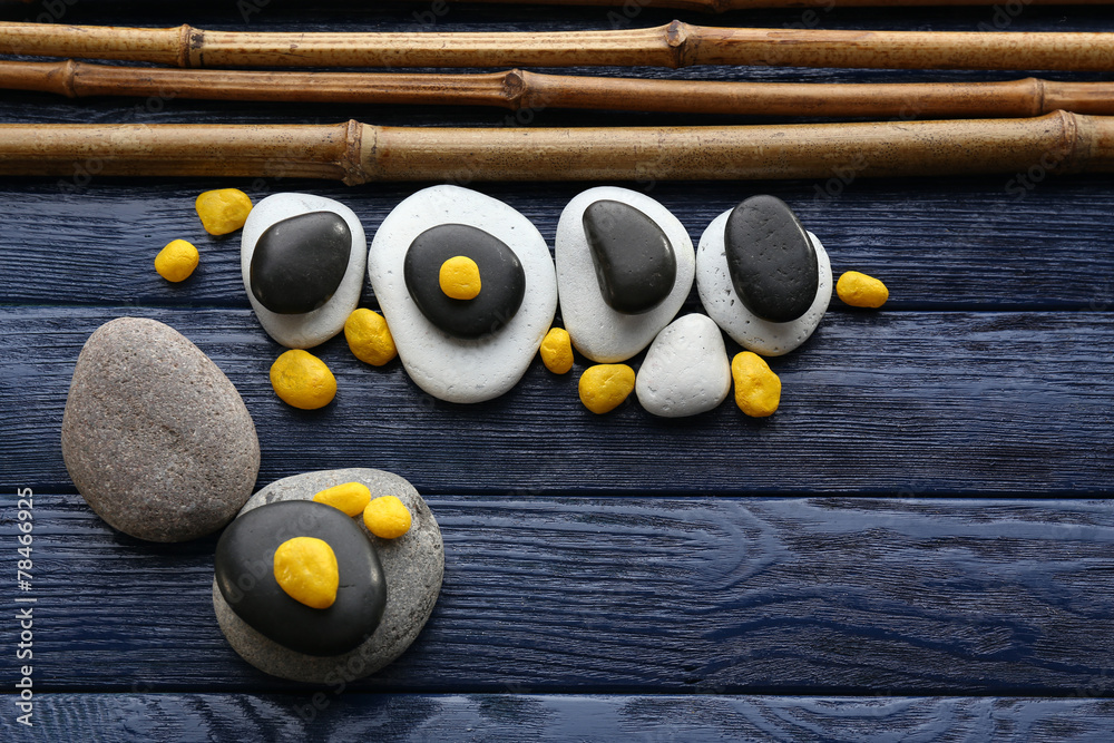 Spa stones with dry bamboo on wooden background