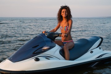 African-american girl sitting on a jet ski