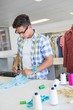 © WavebreakmediaMicro - Fashion student cutting fabric with pair of scissors