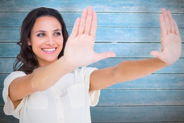 Poster - Composite image of pretty brunette holding up hands
