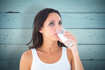 Poster - Composite image of pretty brunette drinking glass of water