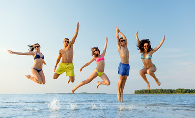 Canvas Print - smiling friends in sunglasses on summer beach