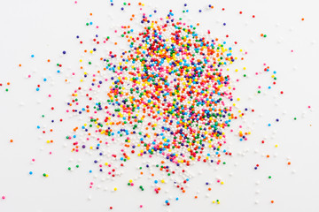 Wall Mural - Colorful round sprinkles spilled on white background, isolated