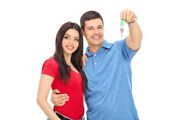 Canvas Print - Studio shot of a young couple posing with a key