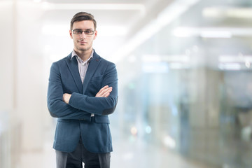 Young handsome businessman wearing glasses in the office and