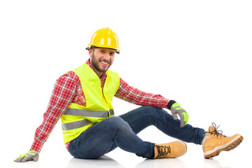 Wall Mural - Relaxed construction worker sitting on a floor