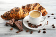 Fresh and tasty croissants with chocolate and cup of coffee