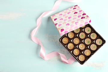 Wall Mural - Gift box with tasty chocolate candies on wooden table